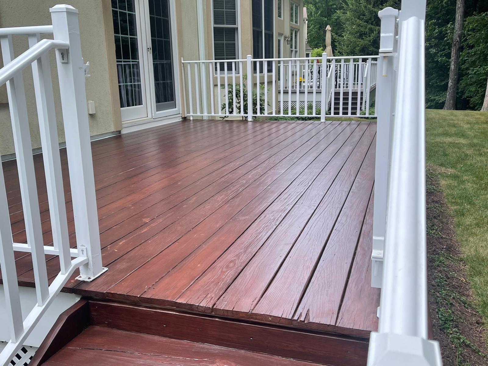 Restained mahogany backyard deck with white railings